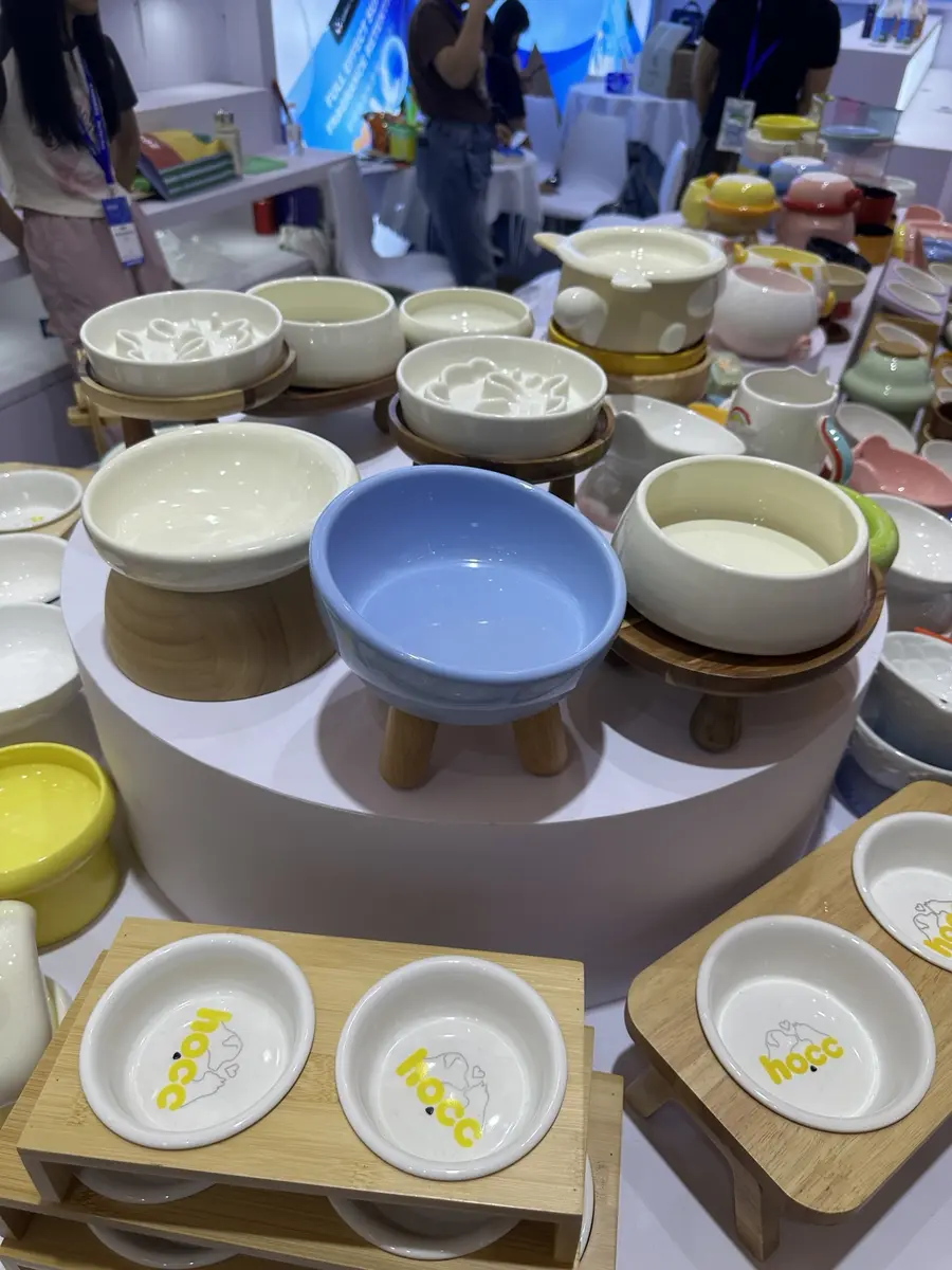 Ceramic pet bowls and raised wooden feeding stands displayed at Pet Fair Asia